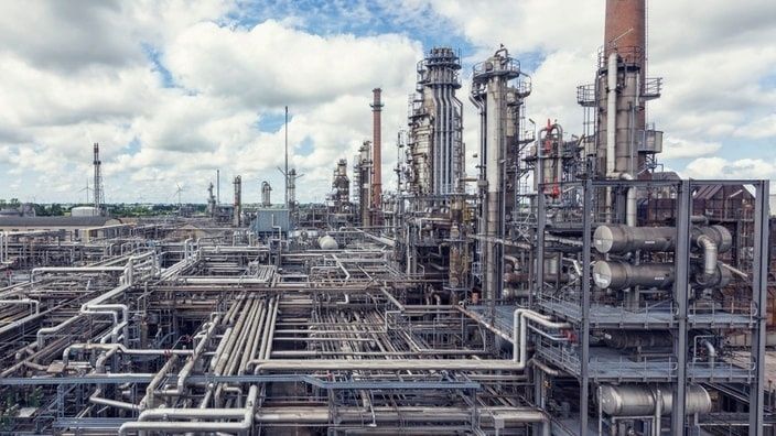 Vue d’une vaste raffinerie industrielle avec colonnes et réseaux de conduites